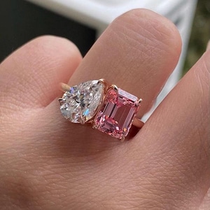 May include: A rose gold ring with a pear-shaped diamond and a pink emerald-cut gemstone.