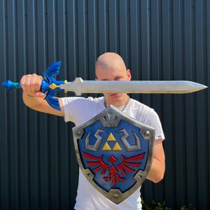 May include: A blue and silver sword with a matching blue shield. The shield has a blue background with a red bird emblem and a gold triangle. The sword has a blue hilt and a silver blade.