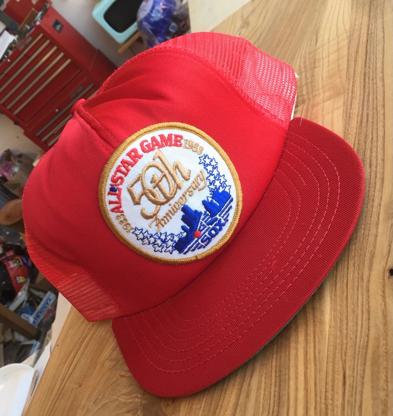 Puede incluir: Gorra de b&eacute;isbol roja y blanca con un parche bordado en oro y azul que dice "1969 All-Star Game 50th Anniversary" con un horizonte y la palabra "SOX".