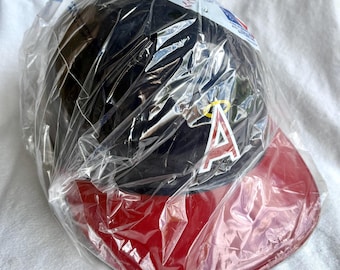 May include: A black baseball cap with a red brim, packaged in clear plastic. The cap features a red and white "A" logo with a yellow halo. The cap is likely a sports team merchandise item.