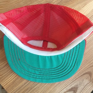 Puede incluir: Gorra de camionero de malla roja y verde con visera blanca. La gorra tiene una parte trasera de malla y una parte delantera s&oacute;lida.