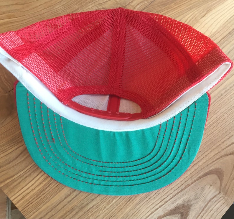 Puede incluir: Gorra de camionero de malla roja y verde con visera blanca. La gorra tiene una parte trasera de malla y una parte delantera s&oacute;lida.