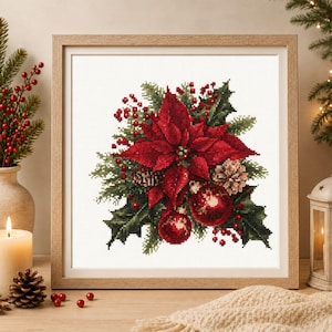 May include: A square framed cross-stitch artwork featuring a central arrangement of a vibrant red poinsettia flower, dark green holly leaves, small red berries, two shiny red Christmas ornaments, and a textured brown pinecone on a white background.