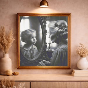 May include: A framed black and white artwork depicts a woman looking into a mirror, reflecting a young girl. The artwork is in a gold frame and is displayed on a wooden surface. The image has a vintage aesthetic.