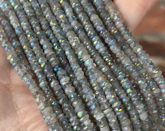 May include: A strand of iridescent gray gemstone beads. The beads are faceted and have a shimmery, opalescent finish.