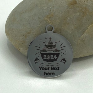 May include: A silver round charm with a cruise ship, the year 2024, and the text "Your text here".