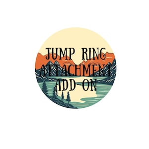 May include: A round sticker with a landscape design featuring mountains, a lake, and trees. The text "JUMP RING ATTACHMENT ADD-ON" is in black, stylized font, over the landscape.