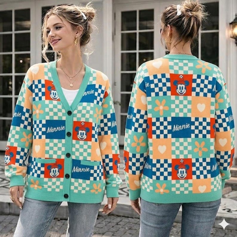 May include: A long-sleeve button-down cardigan featuring a multi-colored checkerboard pattern in shades of teal, orange, and white. The knit garment displays repeating graphics of Minnie Mouse, white flowers, and hearts, with the text Minnie printed.