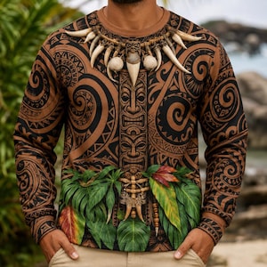 Peut inclure: Un t-shirt à manches longues et col rond arborant un motif tribal marron et noir avec un graphique central de totem vertical. Le design inclut un collier imprimé de dents et de coquillages blancs, superposé à des feuilles tropicales vertes et rouges.