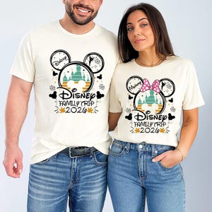 A man and a woman are standing next to each other, both wearing Disney-themed t-shirts.