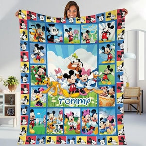 A woman is holding up a colorful quilt featuring various Disney characters, including Mickey Mouse, Minnie Mouse, Donald Duck, and Goofy.