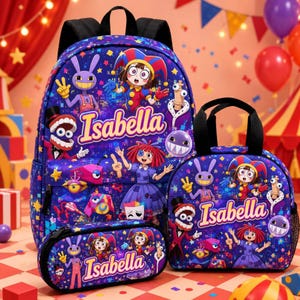 Op de afbeelding: Een paarse rugzak, lunchtas en etui set met een kleurrijke cartoonprint van personages en de naam Isabella in gele tekst. De items zijn versierd met sterren en diverse geanimeerde figuren tegen een donkerpaarse achtergrond.