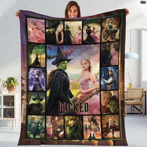 Peut inclure: Une grande couverture rectangulaire avec un collage d'images de la comédie musicale "Wicked". Le motif comprend des portraits de personnages en costumes, le titre "Wicked" et des scènes de la production. La couverture est tenue par une personne.
