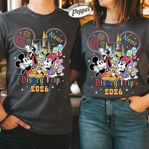 A man and a woman are standing next to each other, both wearing Disney-themed t-shirts.