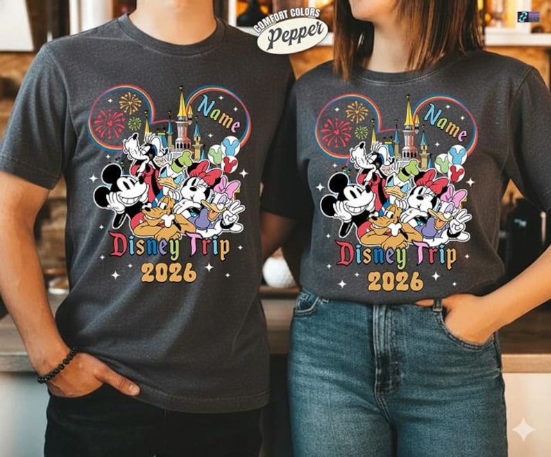 A man and a woman are standing next to each other, both wearing Disney-themed t-shirts.