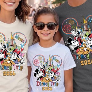 A woman and two children are standing together, each wearing a Disney-themed t-shirt.