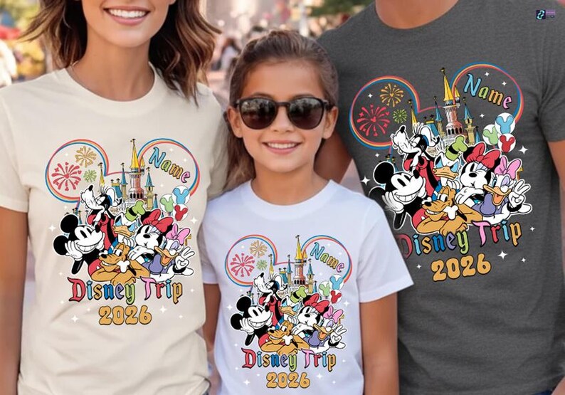 A woman and two children are standing together, each wearing a Disney-themed t-shirt.