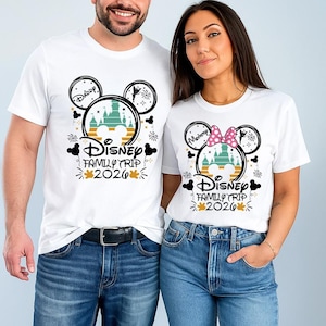 A man and a woman are standing next to each other, both wearing white t-shirts with Disney-themed designs.