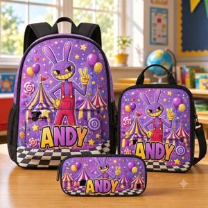 May include: A purple backpack, lunch bag, and pencil case set featuring a cartoon rabbit character in red overalls, a circus tent background, and the name ANDY in yellow letters. The items have a black and white checkered base and star accents.