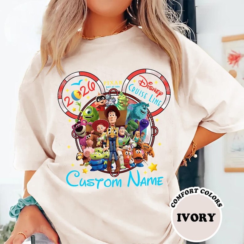 A person wearing a white t-shirt with a colorful graphic design featuring characters from the Disney Pixar movie Toy Story.