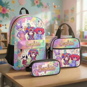 Op de afbeelding: Een set bestaande uit een rugzak, lunchtas en etui met een pastelkleurige regenboogachtergrond, stripfiguren en de naam Sophia in cursief schrift. Elk item toont een paars konijn, een nar en een personage met rood haar.
