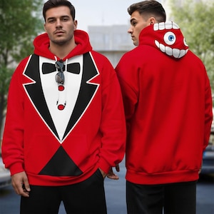 May include: A bright red hoodie featuring a printed tuxedo design on the front with a black bowtie, white shirt front, and red buttons. The hood displays a graphic of a large blue eye surrounded by white teeth on a red background.