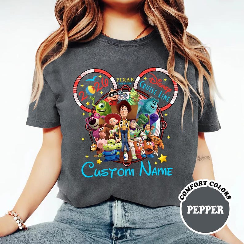 A person wearing a gray t-shirt with a colorful graphic design featuring characters from the Disney Pixar movie Toy Story.