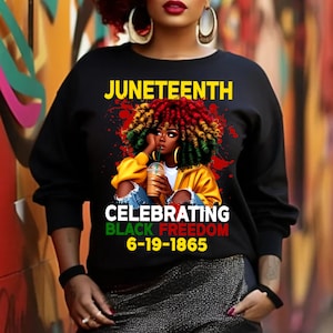 May include: Black sweatshirt with a graphic of a woman with colourful hair and the text "Juneteenth Celebrating Black Freedom 6-19-1865"
