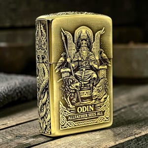 May include: A rectangular brass-toned metal lighter featuring an intricate embossed design of a bearded figure seated on a throne with two wolves and two ravens. The text ODIN ALLFATHER SEES ALL is engraved at the bottom, with Norse knotwork patterns.