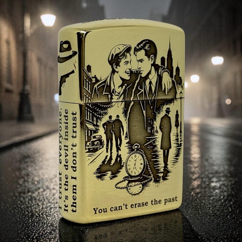 Pu&ograve; includere: Accendino color oro con illustrazioni e testo incisi. Il design presenta due uomini, un orologio da tasca e una scena cittadina. Il testo include "I trust everyone. It's the devil inside them I don't trust" e "You can't erase the past."