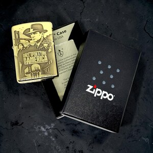 Pu&ograve; includere: Un accendino Zippo color oro con un design inciso del film "Once Upon a Time in America". L'accendino &egrave; esposto con la sua scatola nera, ornata dal logo Zippo e da un motivo a pois bianchi.