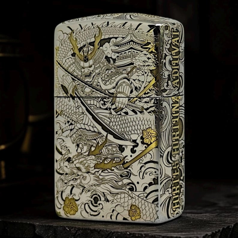 May include: A rectangular silver-toned metal lighter featuring an intricate engraved design of a samurai warrior with a sword, a dragon, and a pagoda. The text FORTES FORTUNA ADIUVAT is vertically inscribed on the side in a bold, serif font.