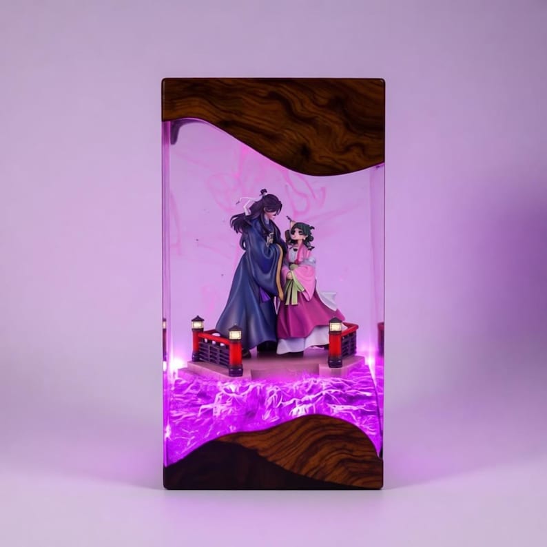 May include: A decorative display case featuring two anime figures standing on a bridge. The figures are dressed in traditional Asian attire. The case has a wooden top and base, with a purple illuminated interior.