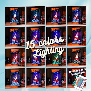 May include: A collection of 15 color-changing LED lamps. Each lamp features a red figure with blue and green accents, set within a clear rectangular casing. The lamps have an orange top and sit on a wooden surface. The image includes the text "15 colors Lighting".