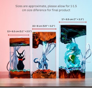 May include: Three rectangular resin lamps with embedded figures. The lamps measure 5.1" x 2.5", 5.9" x 3.2", and 7" x 3.3". One lamp features a black cat with a red bow tie, another a blue monster, and the third a figure in blue water.