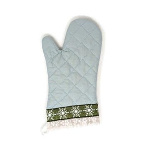 May include: A light blue quilted oven mitt with a white lace trim and a decorative band featuring white snowflakes on a green background. The mitt is designed to protect hands from heat while cooking.