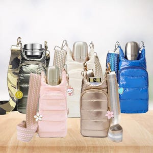 May include: Five quilted water bottle carriers with adjustable shoulder straps in metallic silver, cream, light pink, bronze, and bright blue. Each carrier features a front zippered pocket, a silver metal bottle, and a decorative charm.