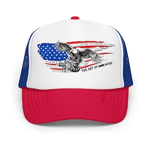 May include: A red, white, and blue trucker hat with a patriotic design. The front panel features an American flag graphic with an eagle and the text "THE ART OF WARWORK". The hat has a white front panel, a red brim, and a blue mesh back.