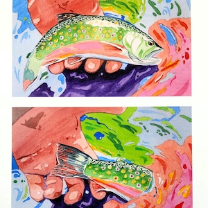 May include: Watercolor painting of two brook trout held in hands. The fish have green, pink, and yellow markings. The background features splashes of blue, pink, and purple watercolor paint. The artwork is on white paper.