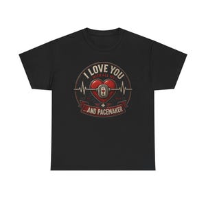 May include: Black t-shirt with a graphic design. The design features a red heart with a pacemaker symbol, a heartbeat line, and the text "I LOVE YOU WITH ALL MY...AND PACEMAKER".