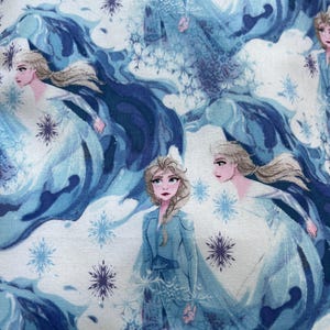 May include: A fabric featuring a repeating pattern of a character from the animated film, "Frozen." The design includes the character in a blue dress, surrounded by snowflakes and flowing blue and white elements.