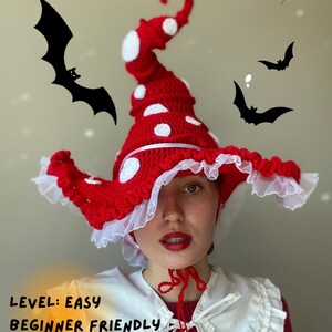 May include: A red and white crocheted mushroom hat with white polka dots and a ruffled brim. The hat has a tall, curved top and is labeled "Level: Easy Beginner Friendly". Black bat silhouettes are in the background.