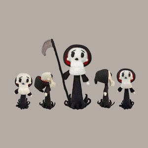 Puede incluir: Cinco figuras de la Muerte de ganchillo, una con una guadaña, en varias poses. Las figuras son negras y blancas con detalles rojos.