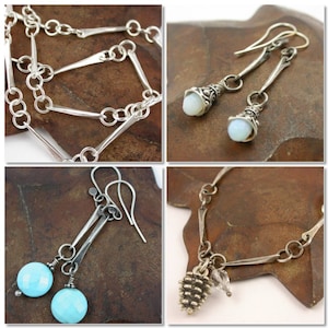 May include: A set of silver jewellery featuring a necklace, earrings, and a charm bracelet. The necklace and bracelet have a chain link design with silver bars. The earrings have a teardrop shape with a silver charm and a white stone. The charm bracelet has a silver charm in the shape of a pine cone.