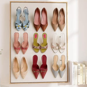 Flat lay illustration of nine pairs of colorful women’s heels arranged in a grid, including floral, pointed-toe, and bow designs – feminine fashion wall art print