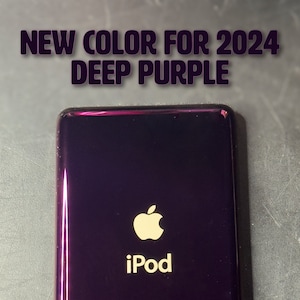 Puede incluir: iPod de color púrpura intenso con el logotipo de Apple y la palabra "iPod" en blanco. El texto "NUEVO COLOR PARA 2024 DEEP PURPLE" está en la parte superior. El dispositivo tiene un acabado brillante y forma rectangular.