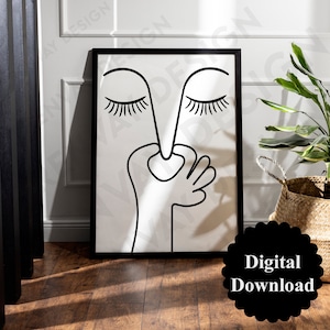Puede incluir: Impresión en blanco y negro de arte de línea de una cara con los ojos cerrados y una mano cubriendo la nariz. La impresión está enmarcada en un marco negro y está colgada en una pared blanca.