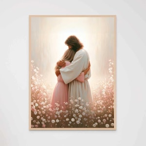 May include: A framed print depicts a tender embrace between two figures. One figure, in a white robe, embraces another in a pink dress. The scene is set in a field of white and pink flowers, bathed in soft light.