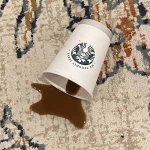 May include: A set of three ceramic mugs with a speckled, matte finish. The mugs are in shades of cream, light gray, and dark gray. Each mug has a simple, minimalist design and a rounded handle.