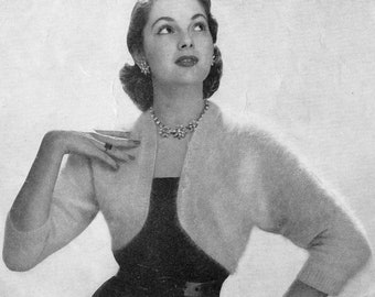 Pode incluir: Uma fotografia a preto e branco de uma mulher a usar um bolero de angorá branco e um chapéu a condizer. O texto "95-4° Cap and Bolero in Patons Fuzzy-Wuzzy Angora P&B WOOLS" está impresso no lado direito da imagem.
